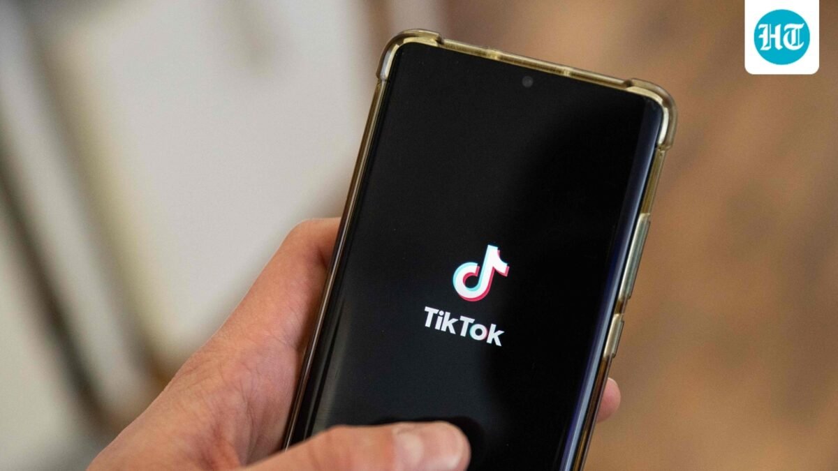 This photograph shows a man holding a smartphone displaying the logo of Chinese social media platform Tiktok in an office in Paris. (AFP)