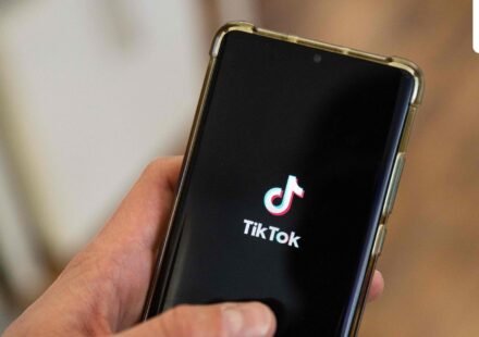 This photograph shows a man holding a smartphone displaying the logo of Chinese social media platform Tiktok in an office in Paris. (AFP)