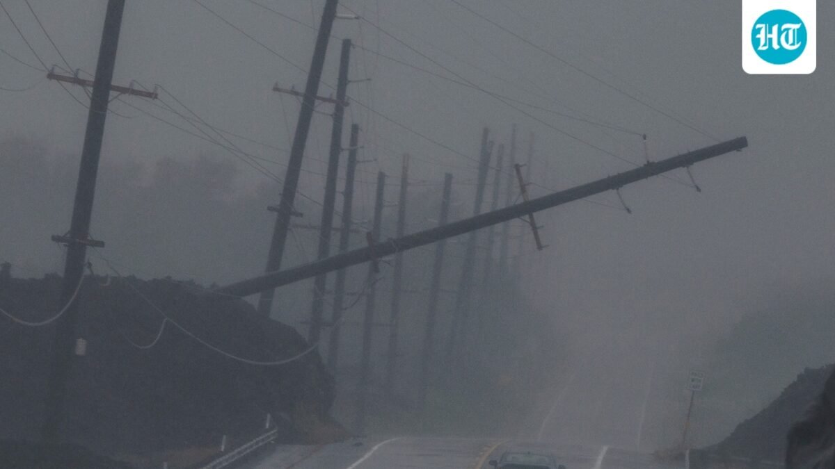 A vehicle drives near a downed utility pole dangling above Mamalahoa Highway during Hurricane Lala near Ocean View, Hawaii. (Stephen Lam/San Francisco Chroni)