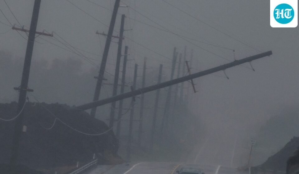 A vehicle drives near a downed utility pole dangling above Mamalahoa Highway during Hurricane Lala near Ocean View, Hawaii. (Stephen Lam/San Francisco Chroni)