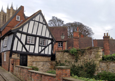 In 1933, Lincoln's Crooked House was marked for demolition; work revealed a hidden timber-framed building behind its brick façade and saved it; today it is one of the Cathedral Quarter's most photographed buildings