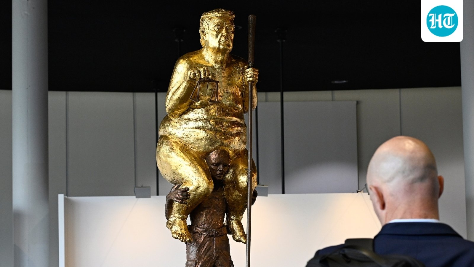 Visitors looks at a sculpture titled "The Orange Plague" by Danish artist Jens Galschiot, depicting US President Donald Trump. (AP Photo/Pascal Bastien)