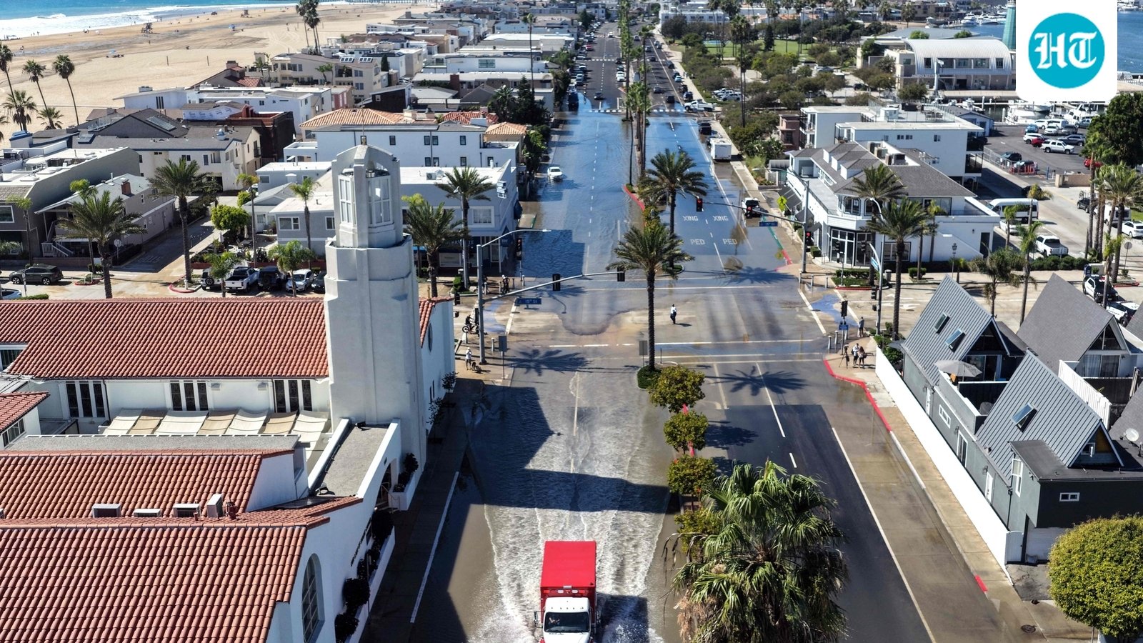 In an aerial view, an emergency vehicle drives through coastal floodwaters amid strong waves and high tides generated by Tropical Storm Rachel on October 9, 2026 in Newport Beach, California. (Getty Images via AFP)